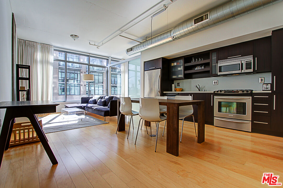 a living room with stainless steel appliances granite countertop furniture a kitchen view living room and a couch