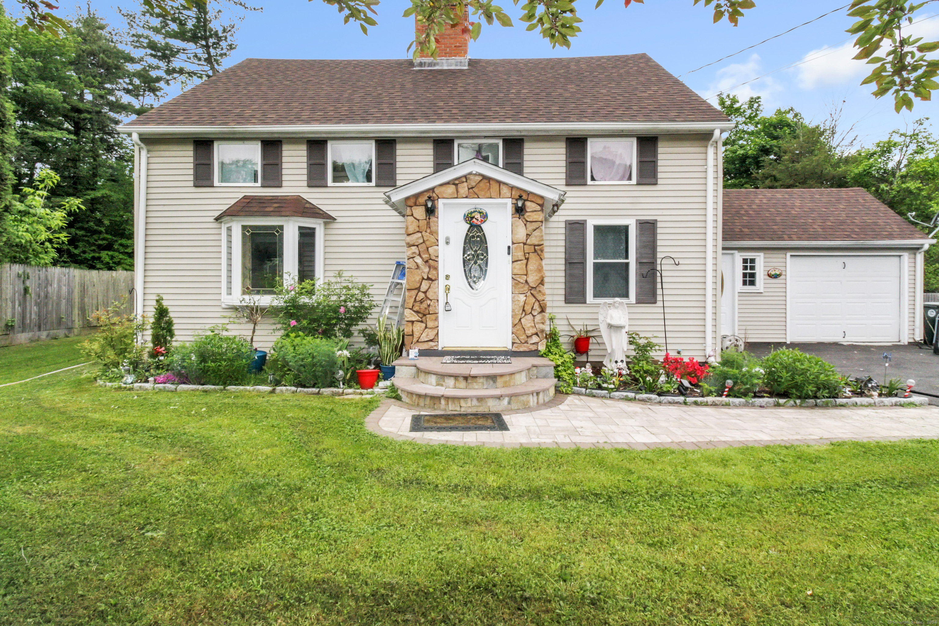 a front view of a house with a garden and yard