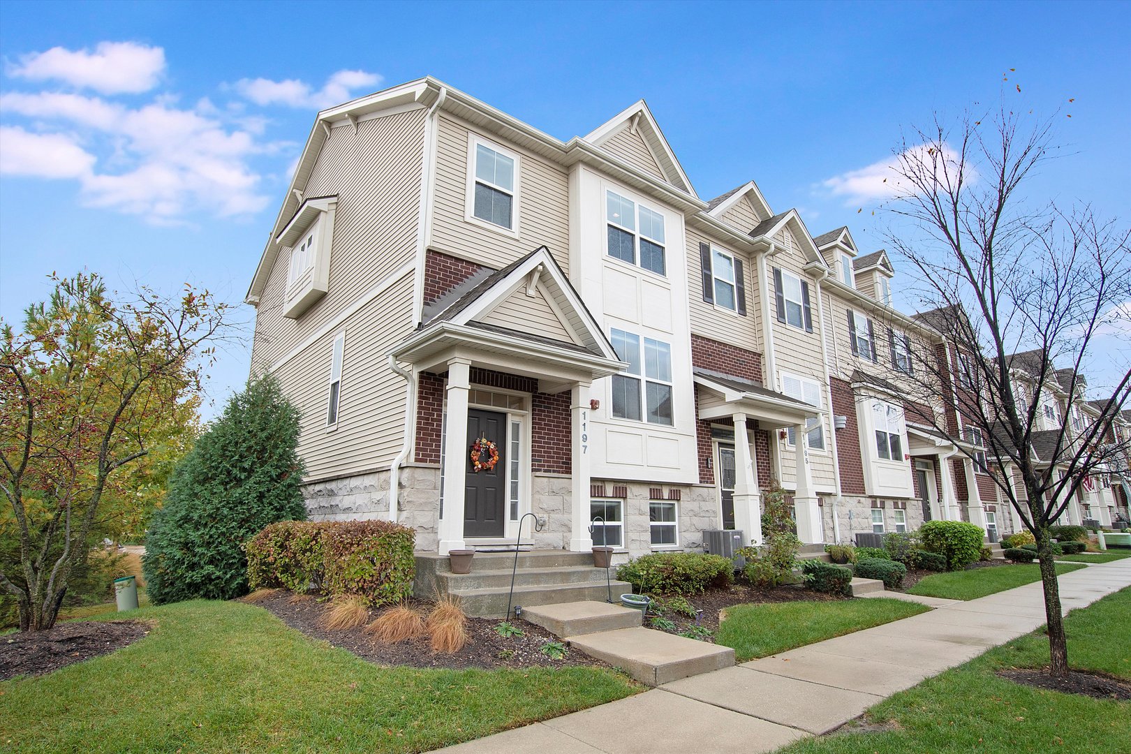 a front view of a residential houses with yard and green space