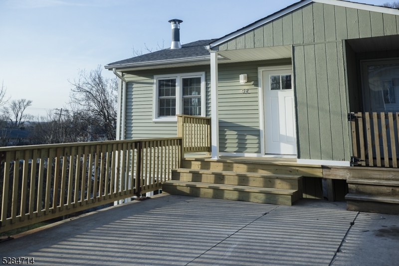 a view of a house with a small yard and wooden floor and fence