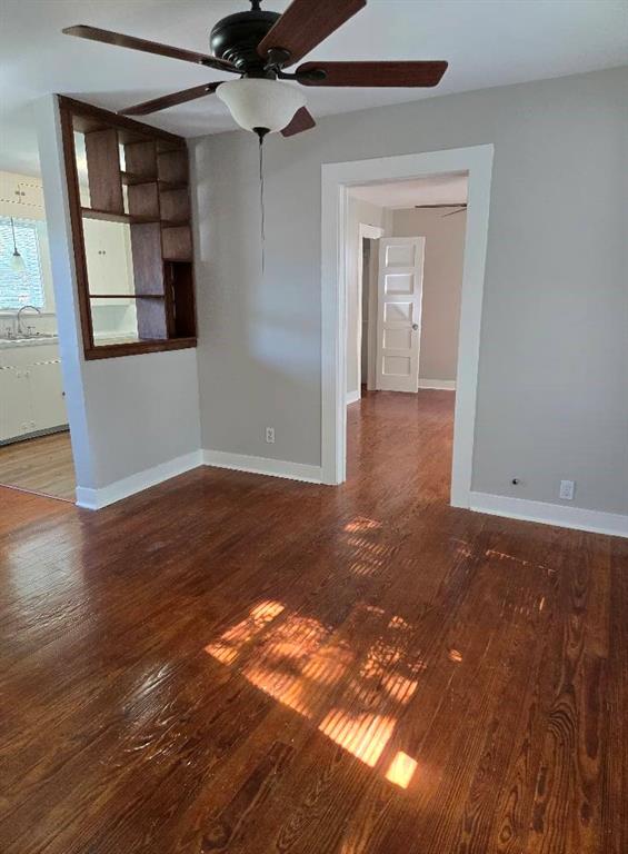 a view of a big room with wooden floor and windows