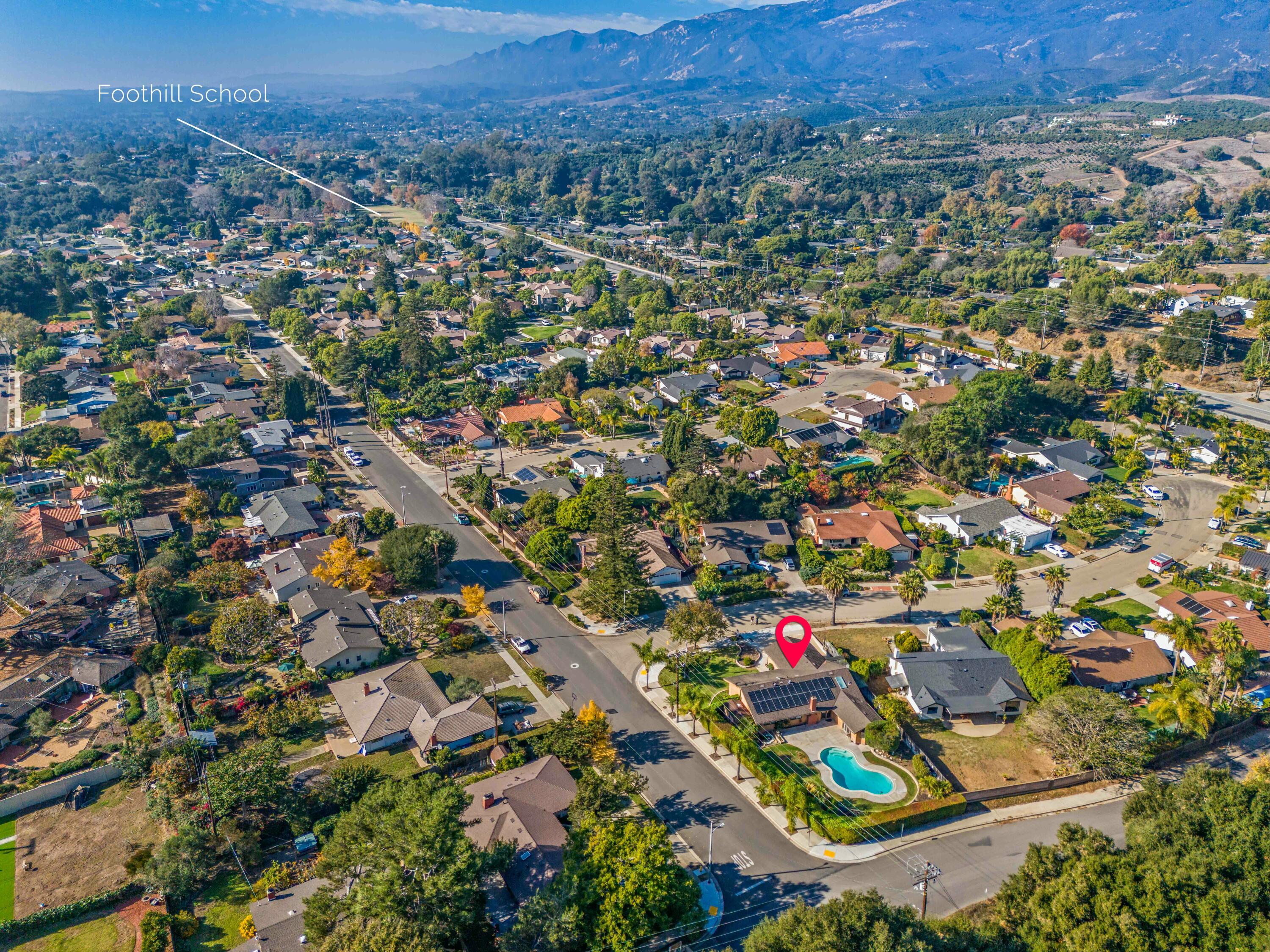 an aerial view of residential houses with outdoor space and trees