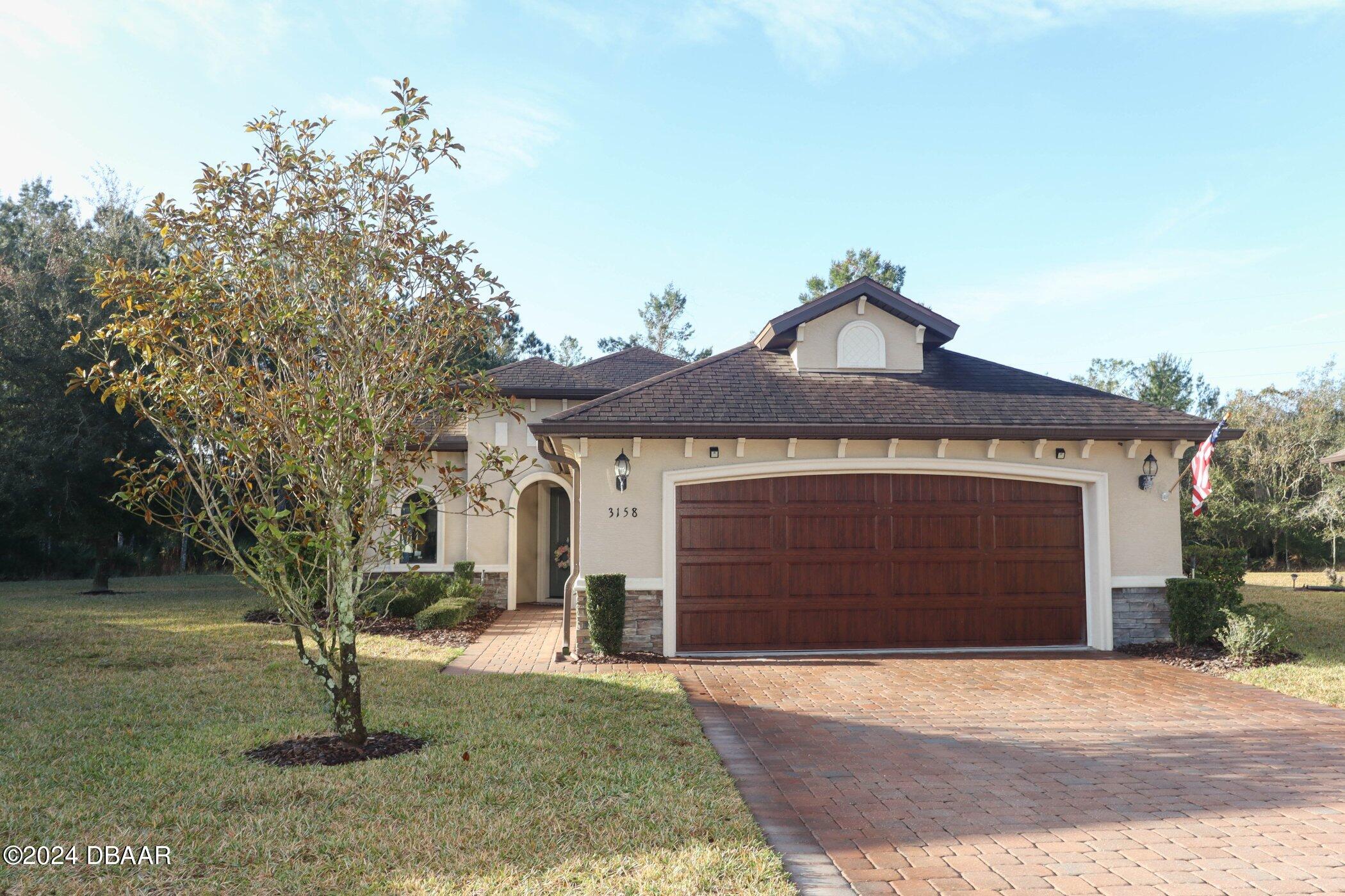 a front view of a house with a yard and garage