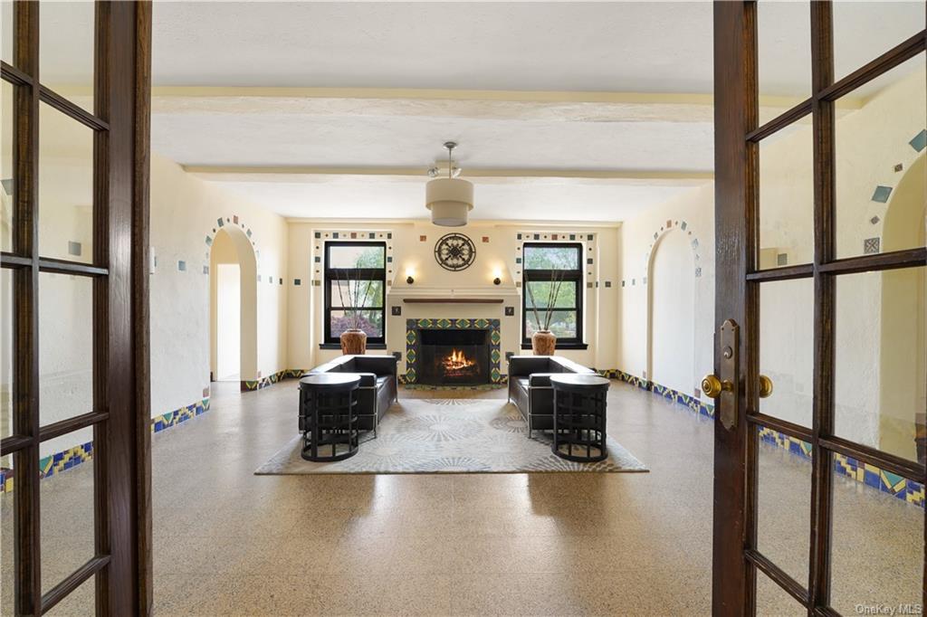 a living room with furniture a fireplace and a chandelier