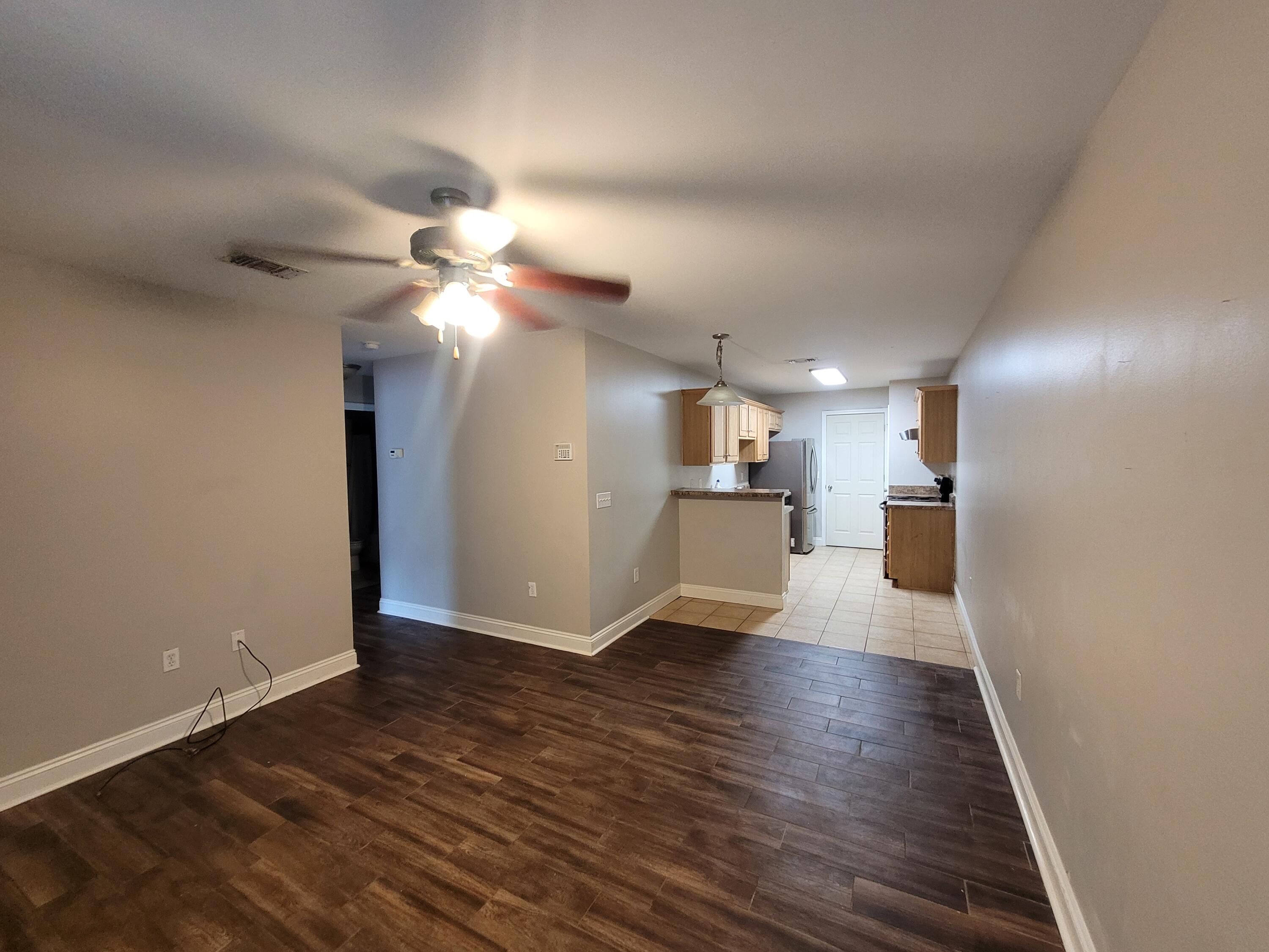 a view of empty room with wooden floor