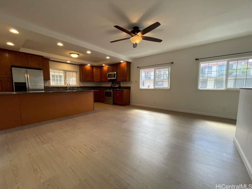 an empty room with a kitchen and windows