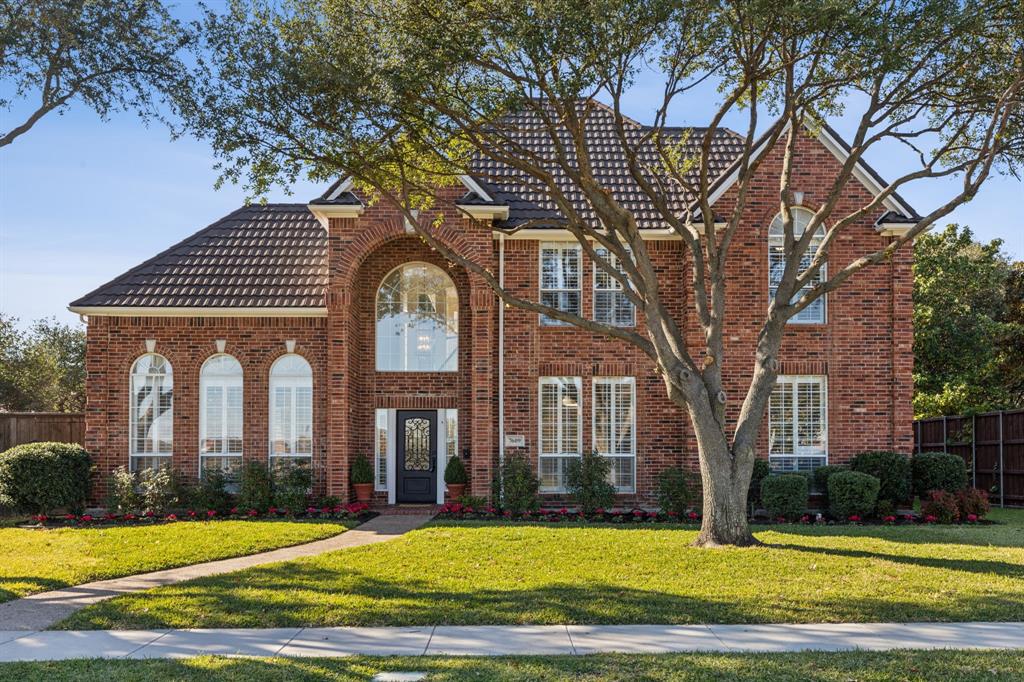 a view of a house with a big yard and large trees