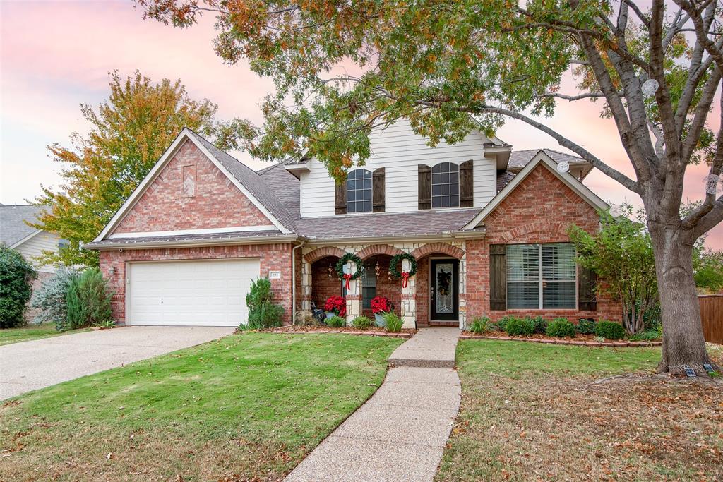 View of front of house featuring a garage and a yard