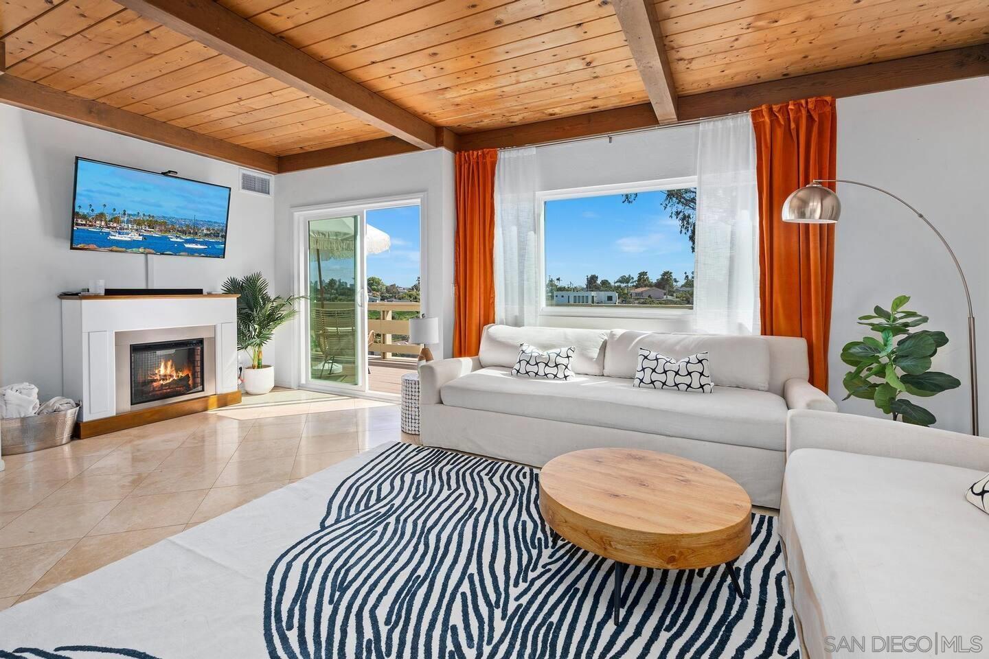 a living room with furniture a fireplace and a large window