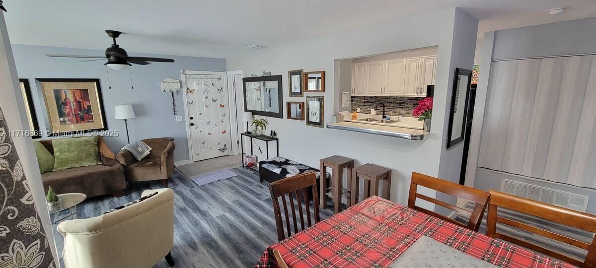 a living room with furniture and a refrigerator