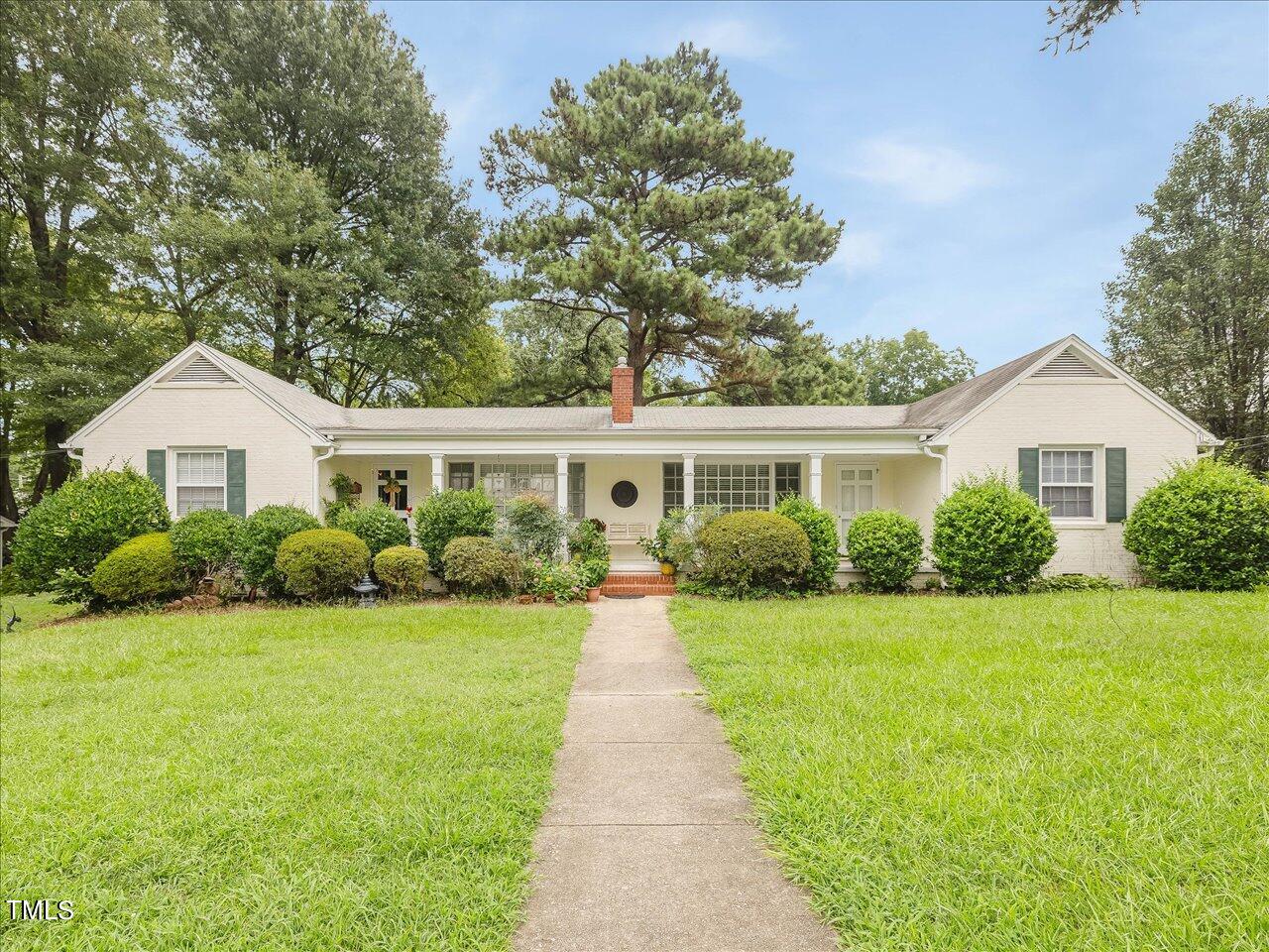 a front view of a house with a garden and yard