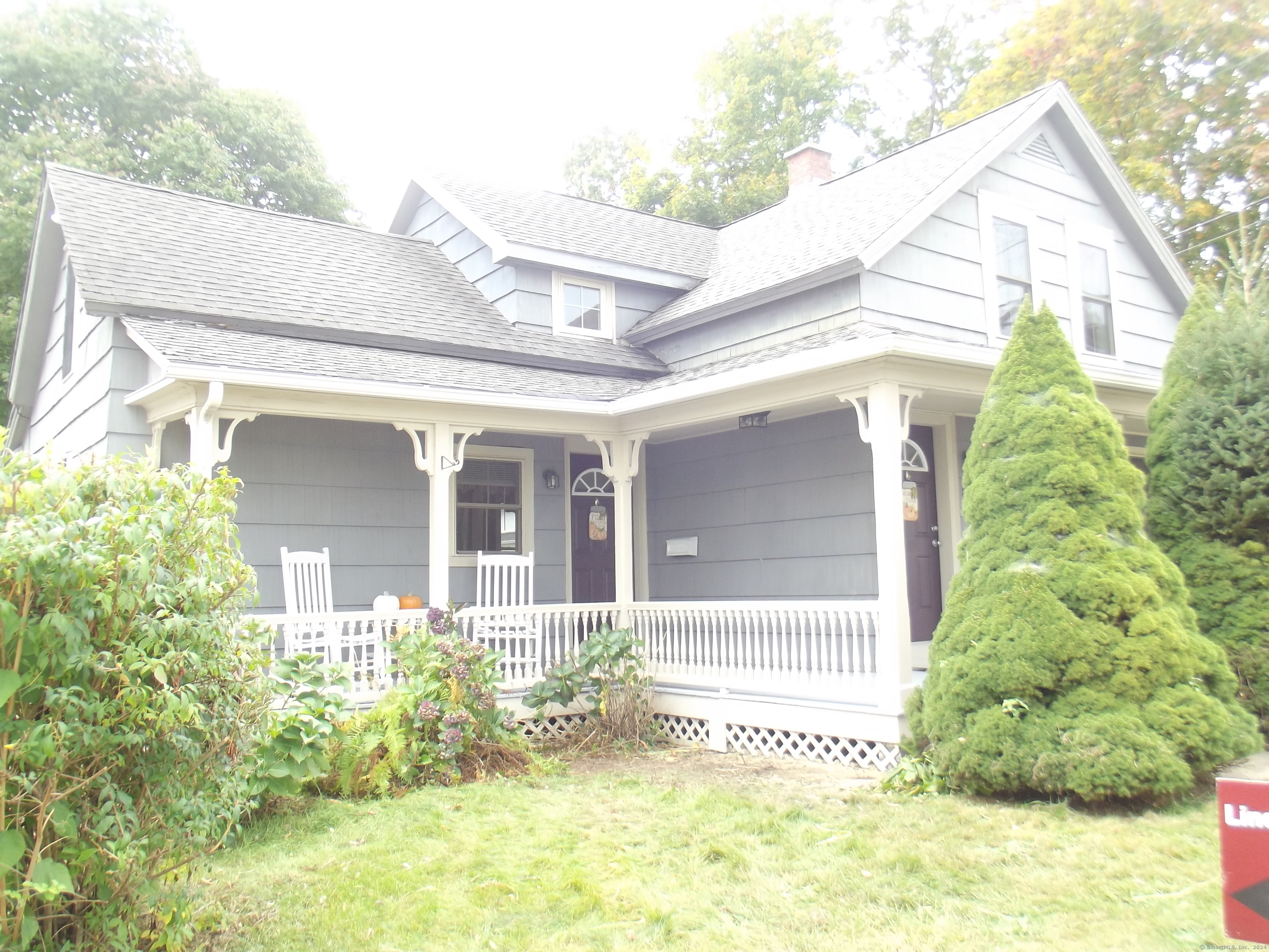 a view of a house with potted plants and a table and chairs