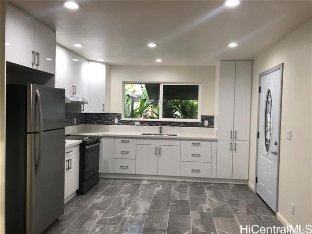 a large kitchen with a refrigerator and a sink