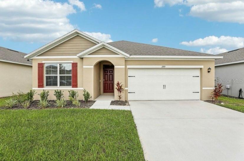 a front view of a house with a yard and garage