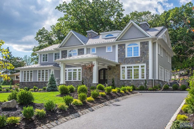 a front view of a house with a yard and potted plants