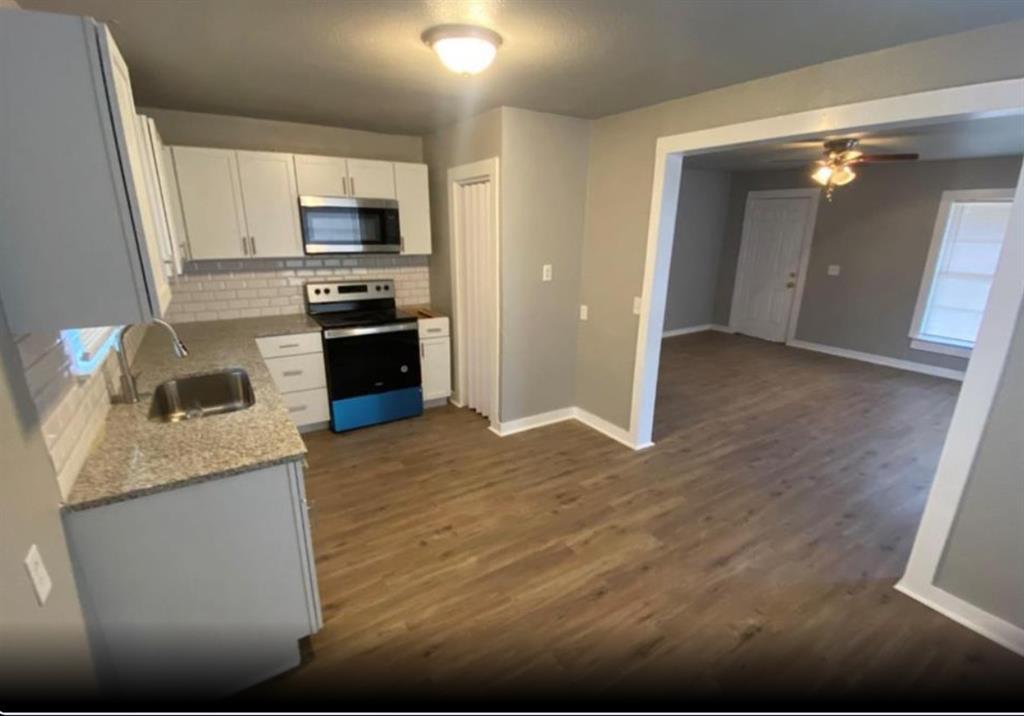 a kitchen with granite countertop white cabinets and stainless steel appliances