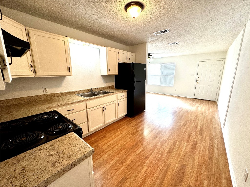 a kitchen with stainless steel appliances granite countertop a stove a sink and a refrigerator