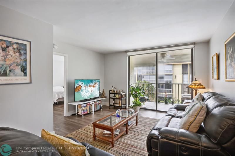 a living room with furniture a flat screen tv and a large window