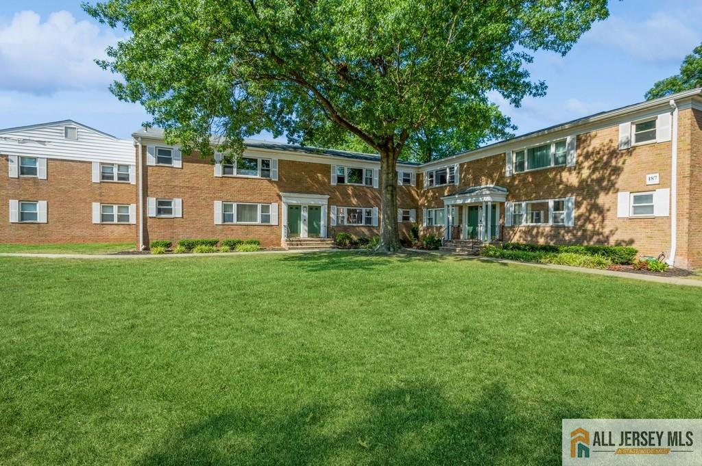 a front view of a house with a yard and trees