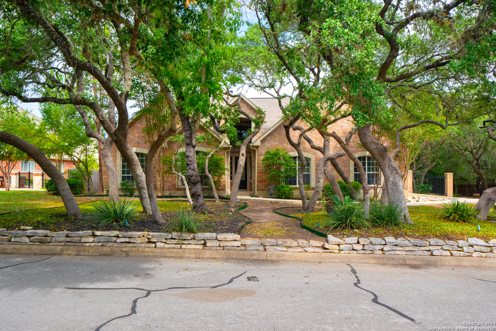 a front view of a house with a yard and tree s