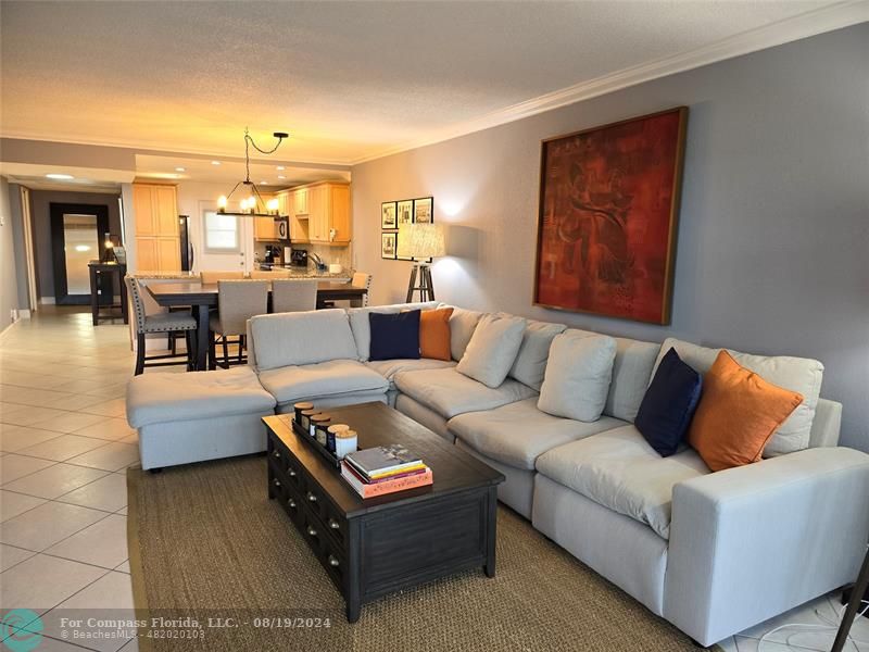 a living room with furniture and a view of kitchen