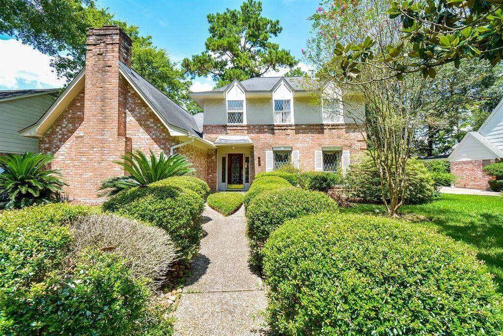 a view of a house with brick walls and flower plants