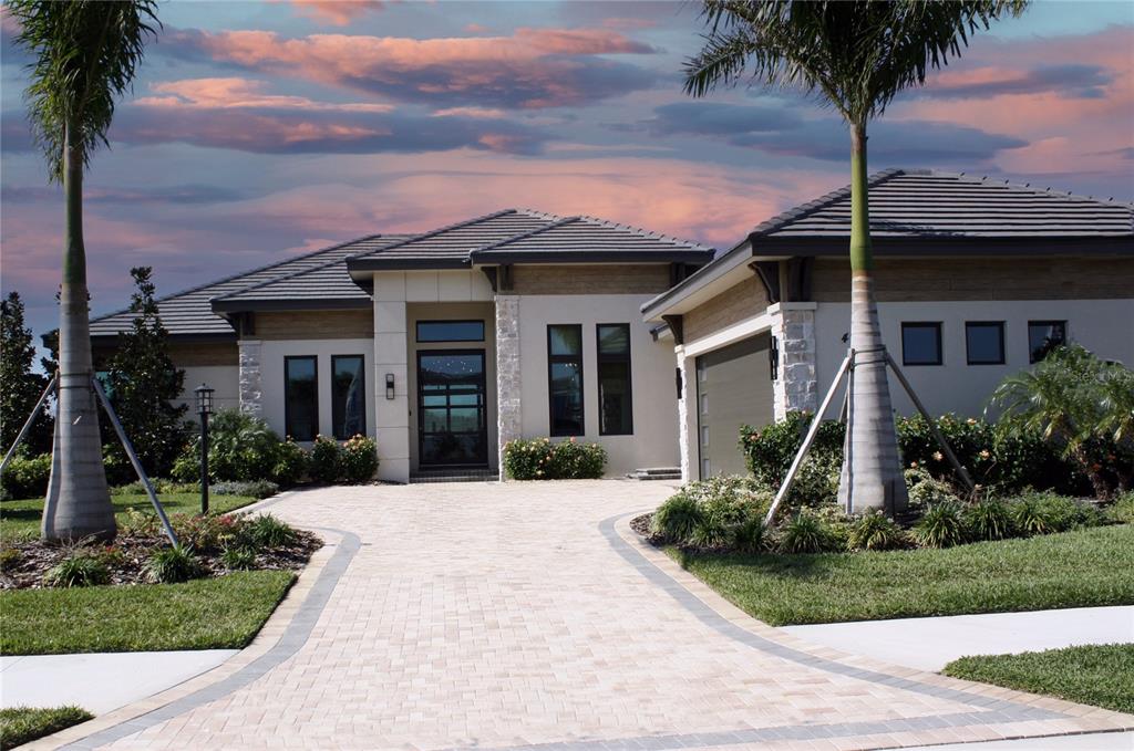 front view of a house with a yard and palm trees