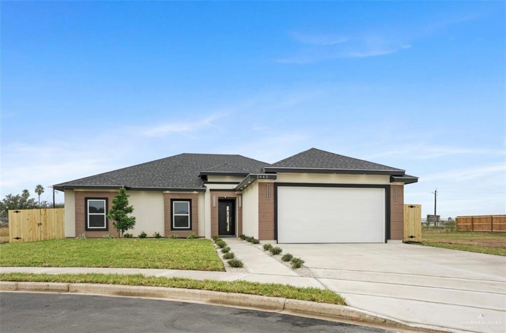 View of front facade featuring a front lawn and a garage