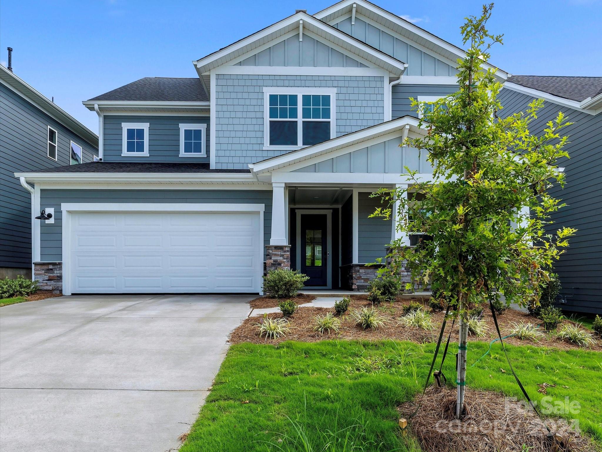 a front view of a house with a garden and yard