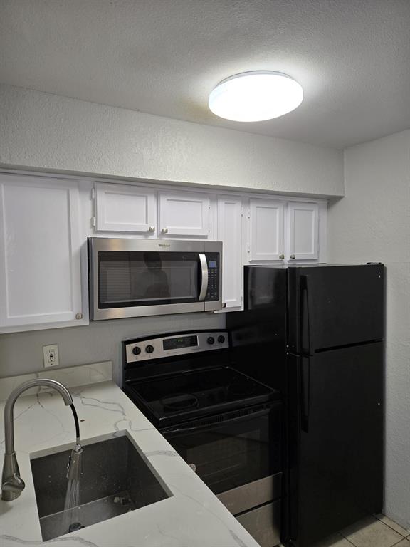 a kitchen with a refrigerator sink and microwave