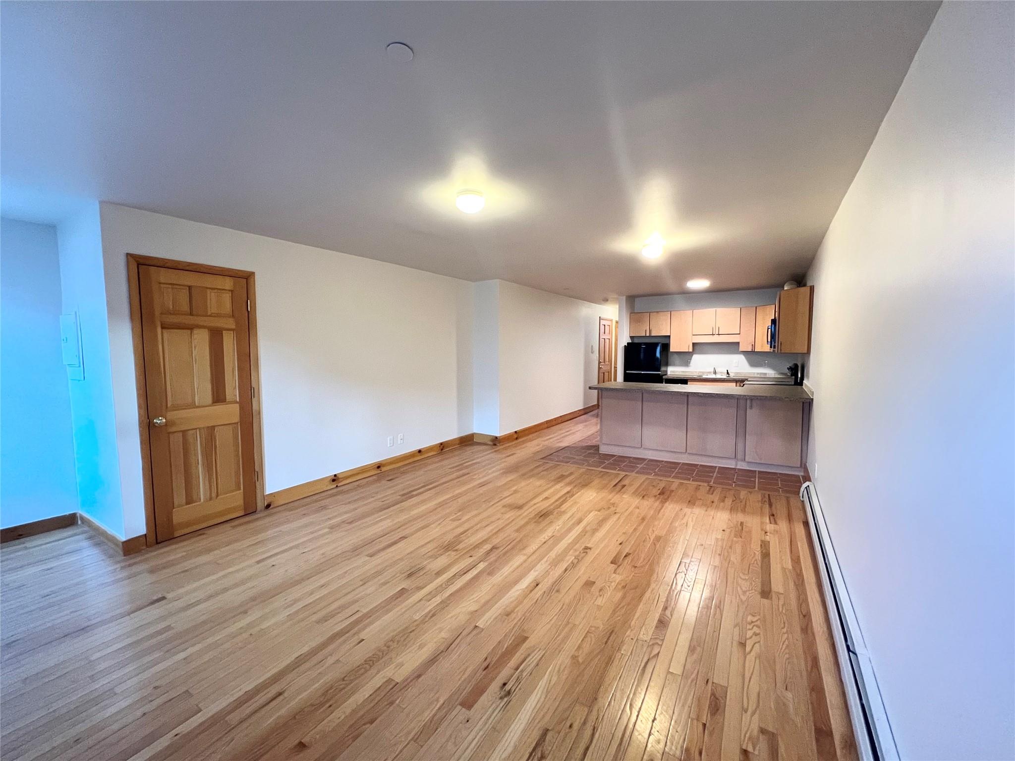 a view of a kitchen with wooden floor and electronic appliances