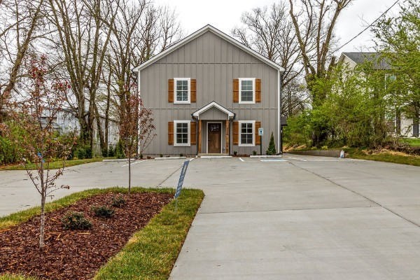 a front view of house with a yard and trees