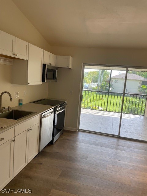 a kitchen with stainless steel appliances a sink and a wooden floor