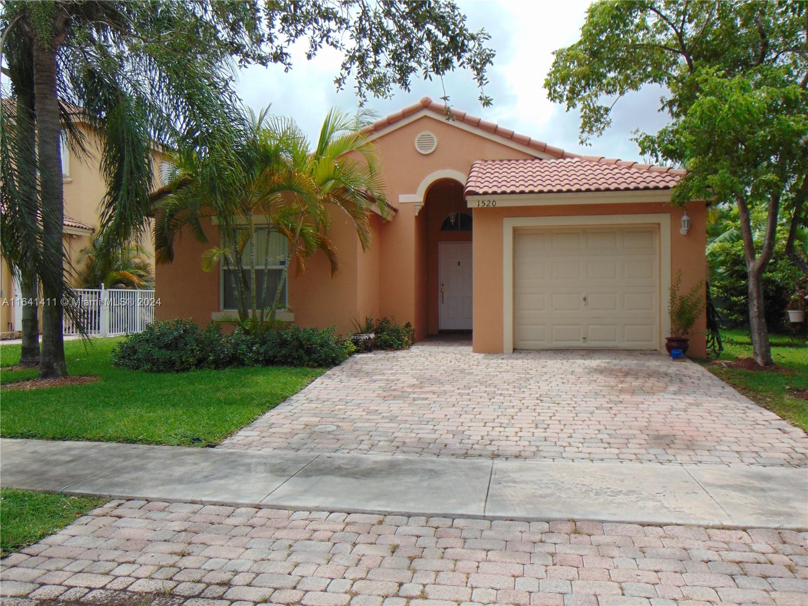 a front view of a house with a yard and trees