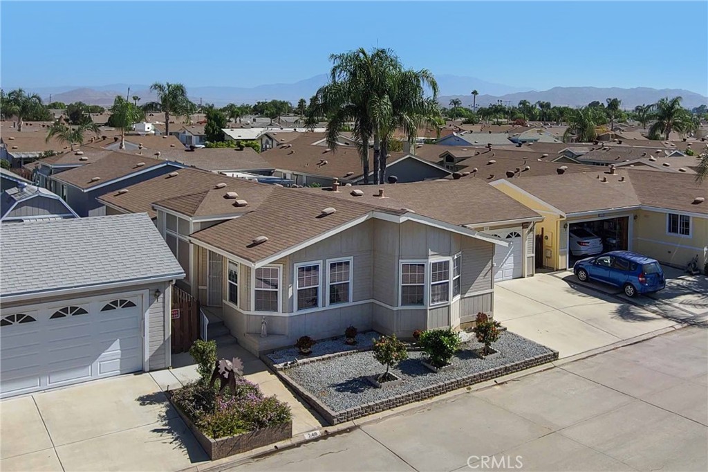 an aerial view of a house with a garden and mountain view in back