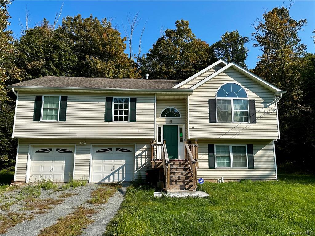 Raised ranch with a front yard and a garage