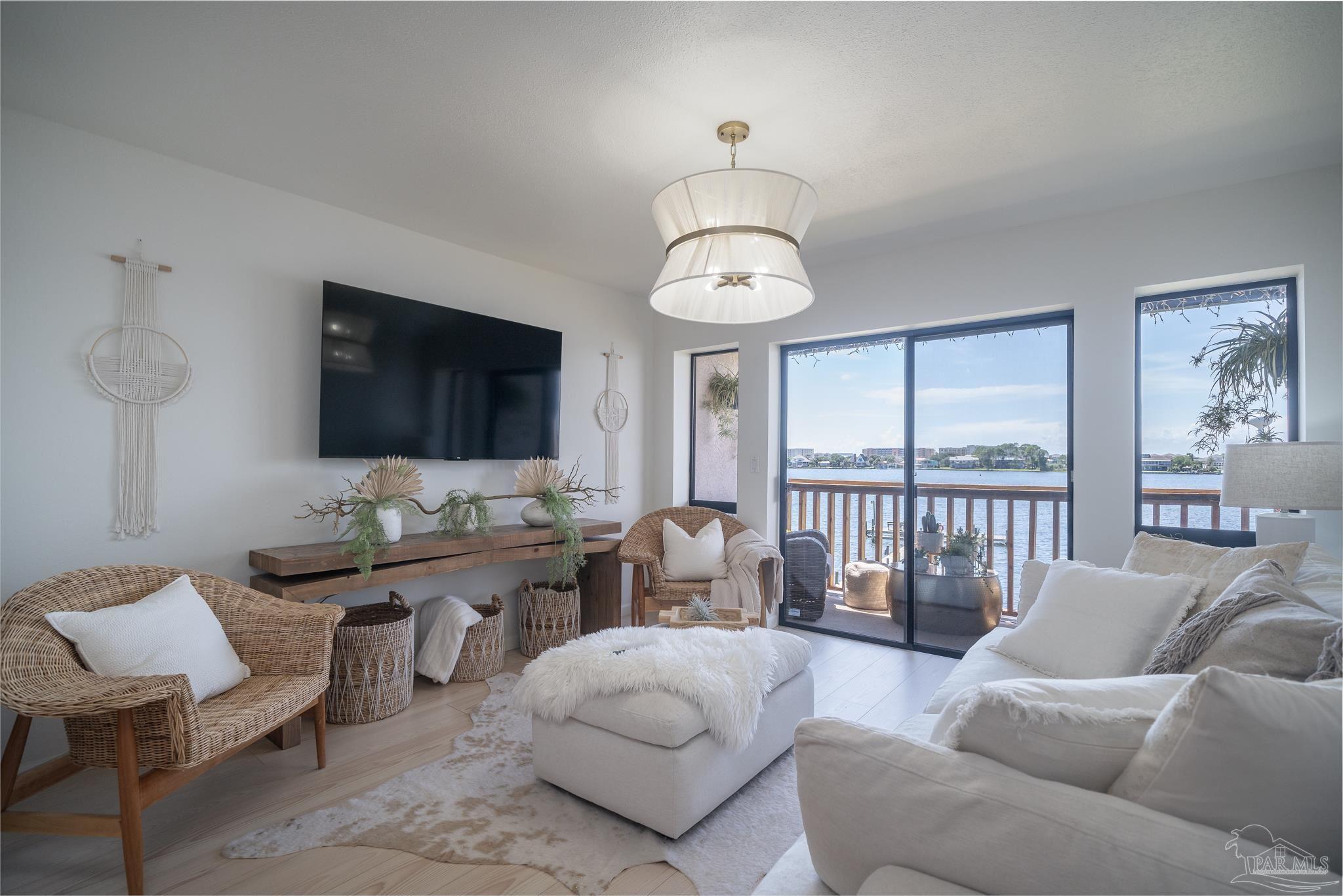 a living room with furniture kitchen view and a flat screen tv