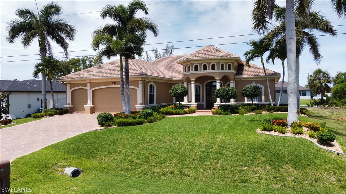 a front view of a house with garden and palm tree