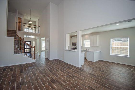 a view of a big room with wooden floor and windows