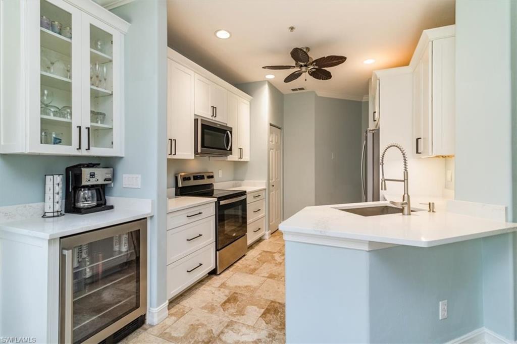 a kitchen with kitchen island granite countertop a sink stainless steel appliances and cabinets