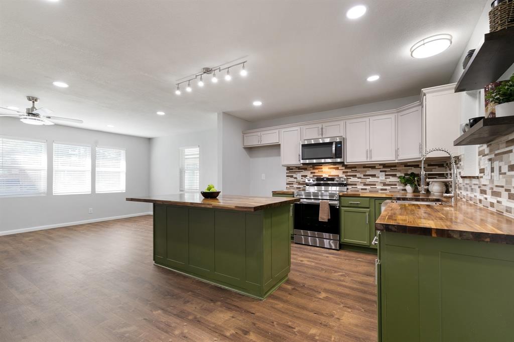 a kitchen with kitchen island granite countertop a sink cabinets and wooden floor