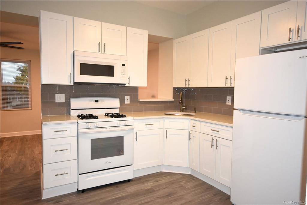 a kitchen with cabinets appliances a sink and a counter space