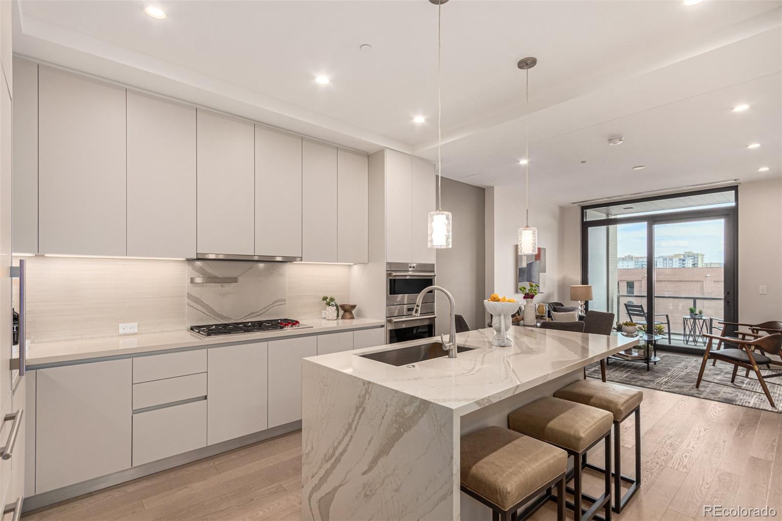 a kitchen with a dining table chairs sink and white cabinets