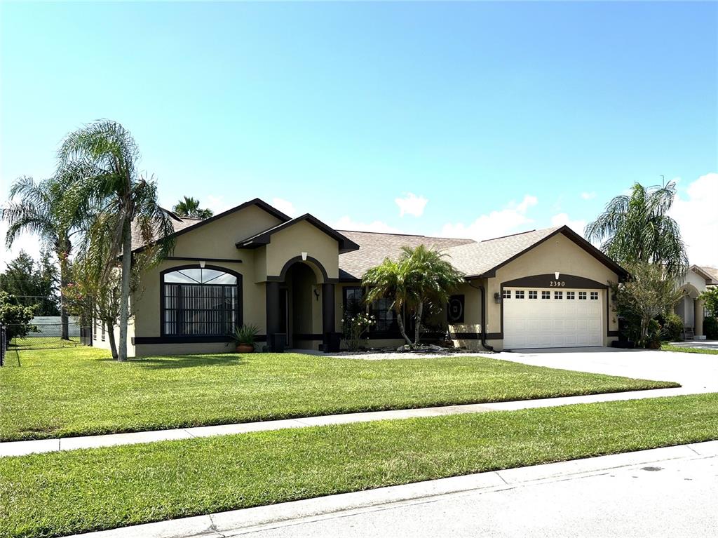 a front view of a house with a yard and trees