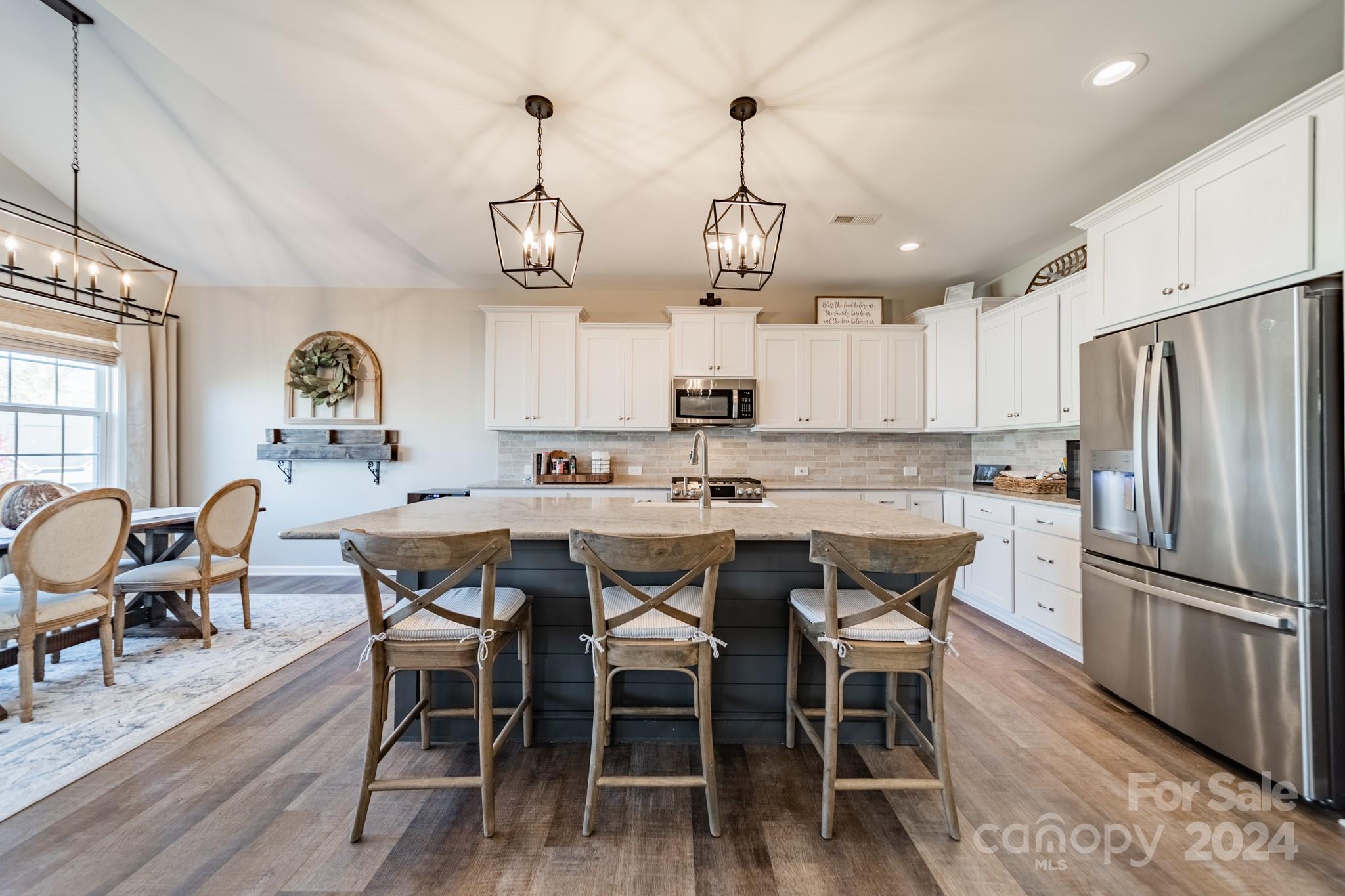 a view of a dining room and livingroom with furniture wooden floor a chandelier