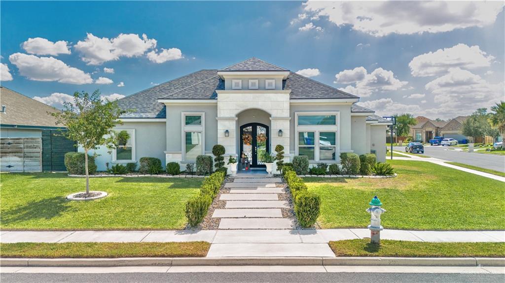 a front view of a house with swimming pool garden and outdoor seating