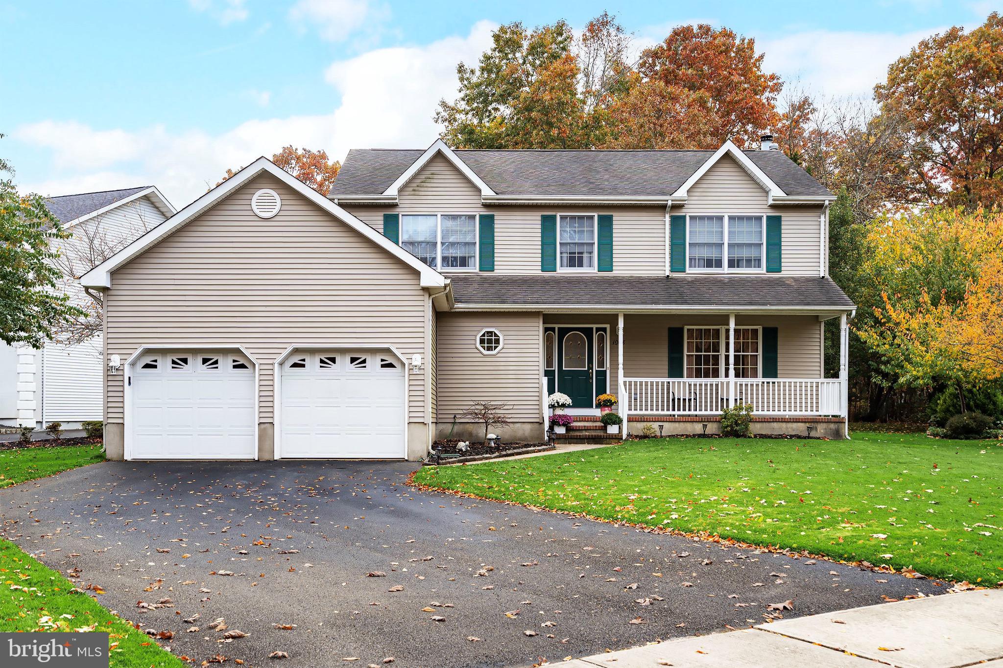 a view of a house with a yard and large trees