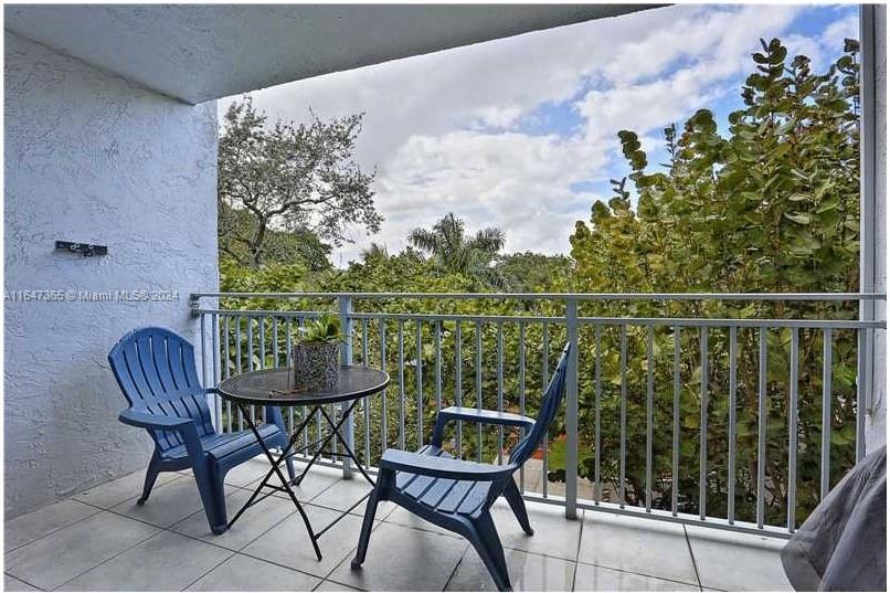 a balcony with table and chairs