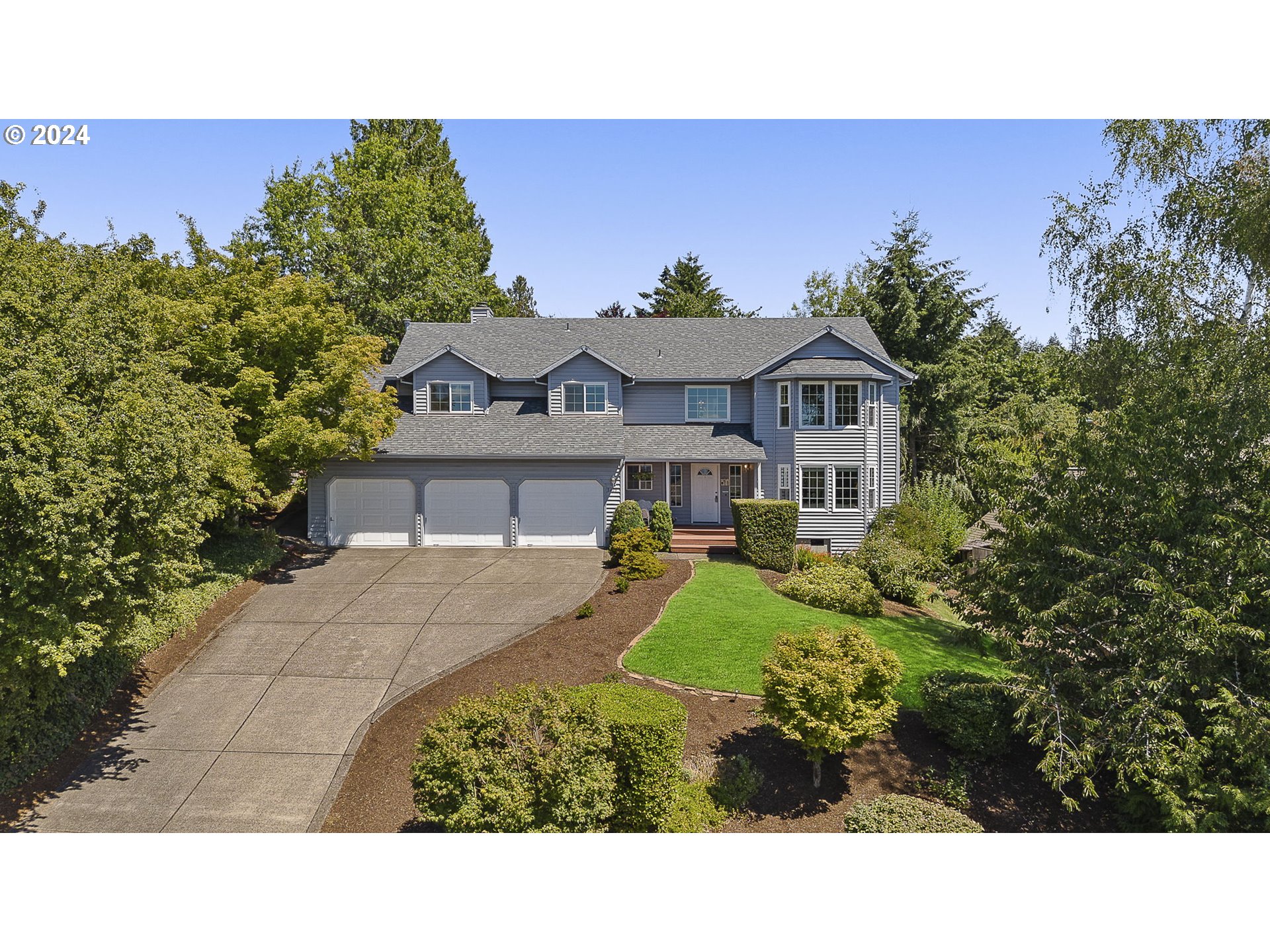 a view of a house with a big yard plants and large trees