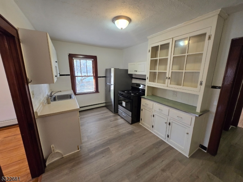 a kitchen with a refrigerator and a stove top oven